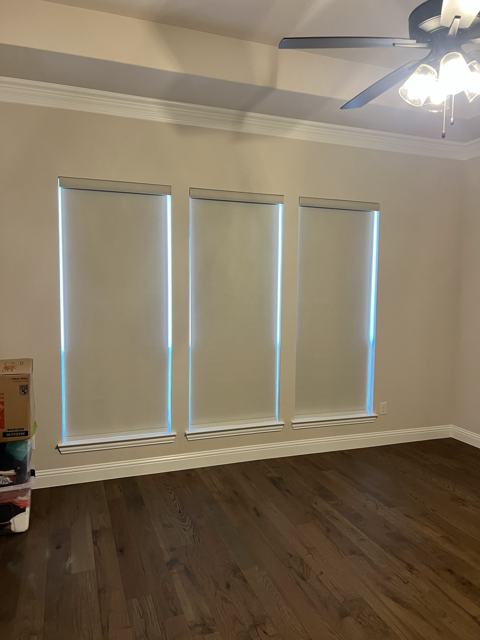 Roller shades on a bedroom window trio