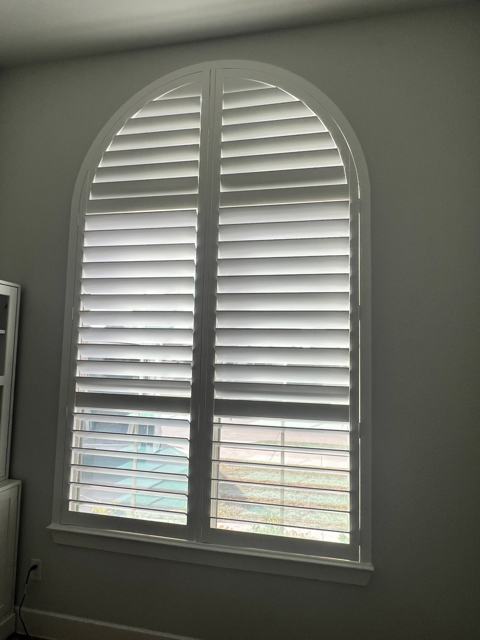 Arched plantation shutters in a living room